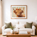 Finished highland cow with floral crown cross stitch artwork displayed as home decor