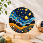 Finished hills under the whimsical night sky needle felting displayed on a wooden easel