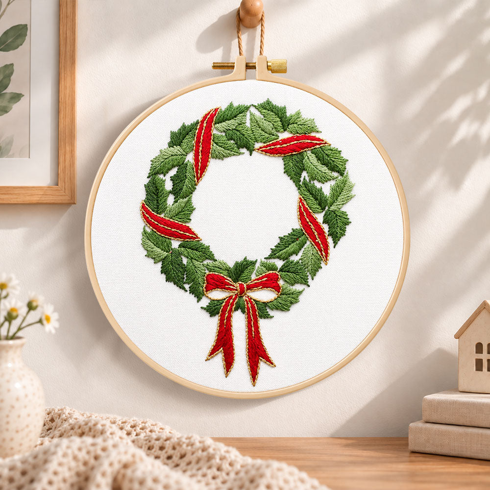 Holly wreath with bow embroidery hoop wall art displayed as warm and cozy handmade home decor