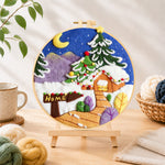 Finished "home" sign and christmas tree cabin needle felting displayed on a wooden easel