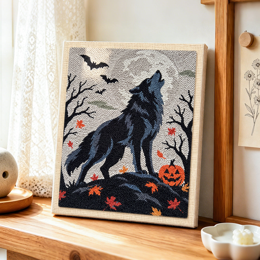 Howling wolf on halloween night punch needle artwork displayed on a table