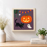Finished jack o lantern and cat artwork displayed on a wall
