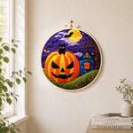 Jack-o'-lantern and haunted house needle felt wall art displayed in a bright home interior