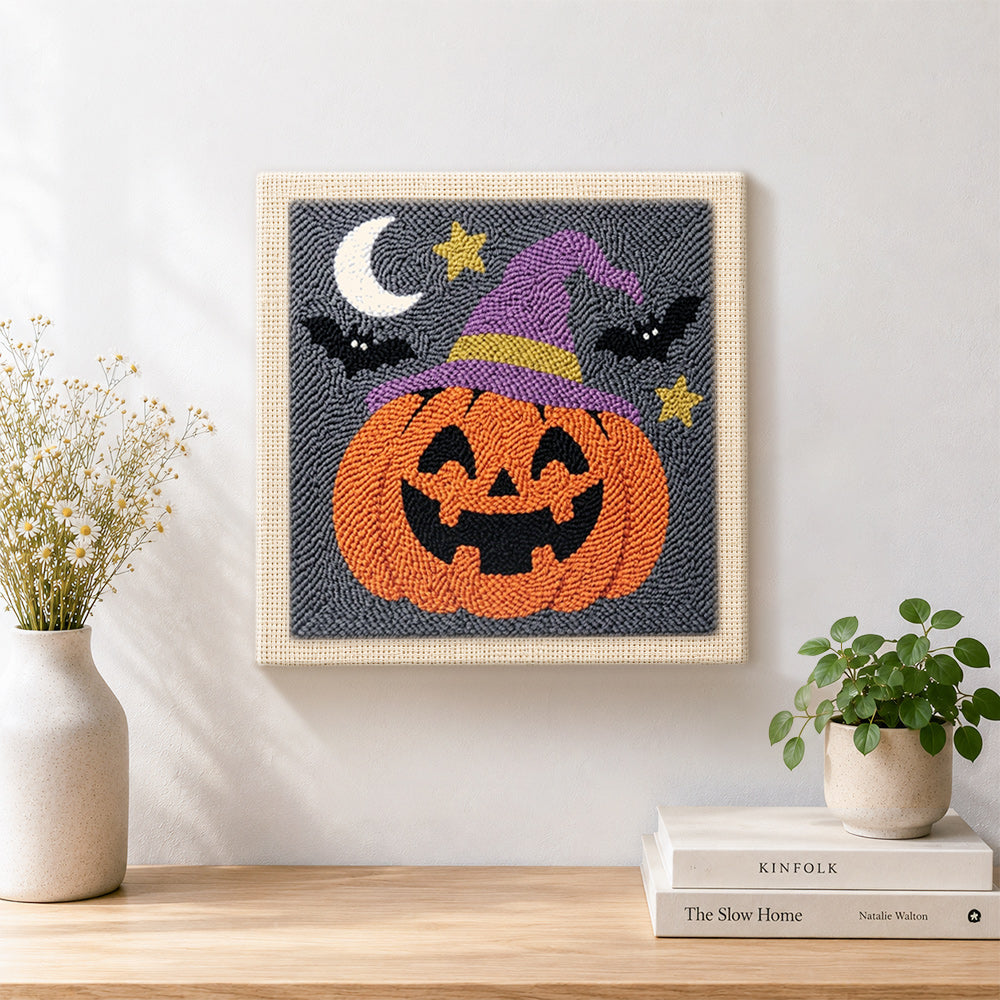Finished jack o lantern wearing witch hat artwork displayed on a wall