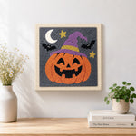 Finished jack o lantern wearing witch hat artwork displayed on a wall