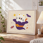 Kitten in witch costume punch needle artwork displayed on a table