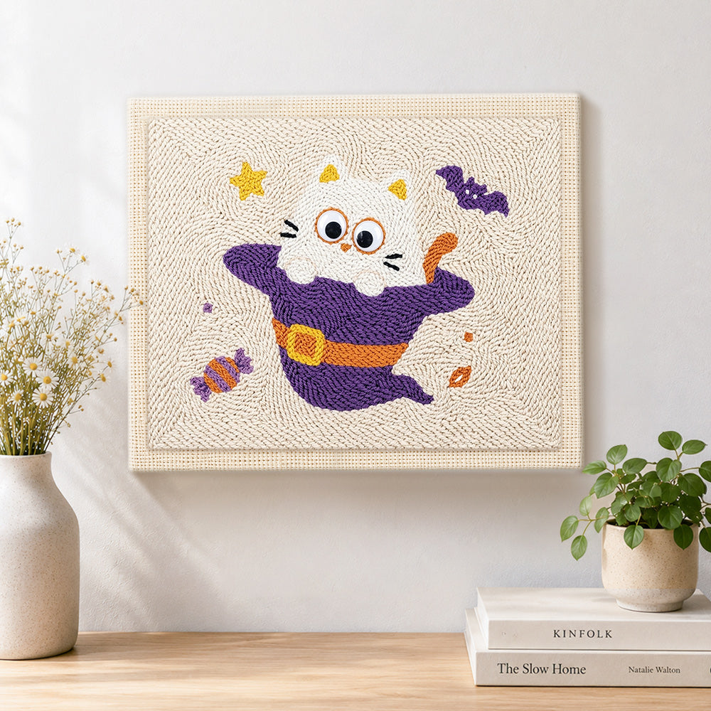 Finished kitten in witch costume artwork displayed on a wall