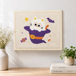 Finished kitten in witch costume artwork displayed on a wall