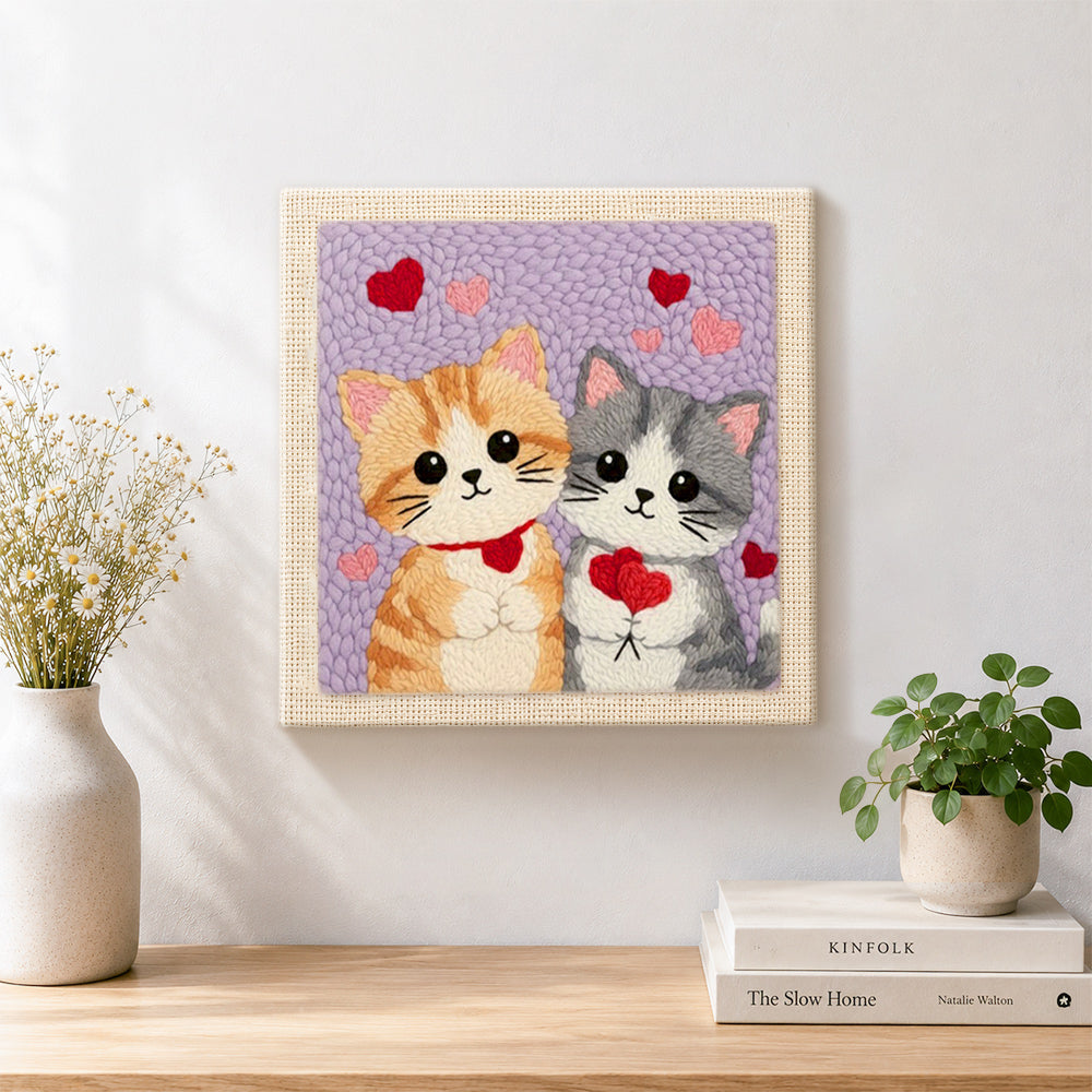 Finished kittens holding hearts artwork displayed on a wall