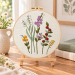 Lavender wildflower embroidery kit finished hoop displayed on a wooden stand as cozy tabletop decor