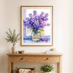 Finished lilac in glass jar cross stitch artwork displayed as home decor