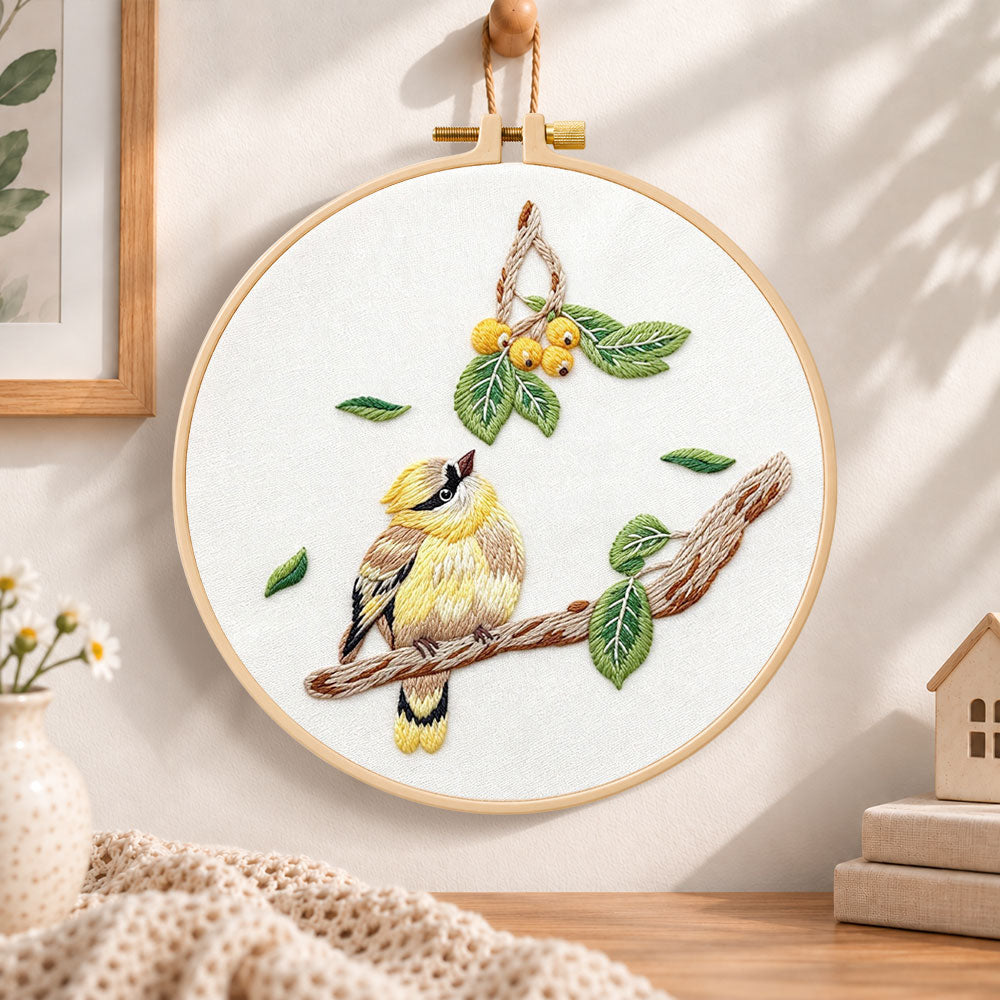 Little bird looking at loquat fruits embroidery hoop wall art displayed as warm and cozy handmade home decor