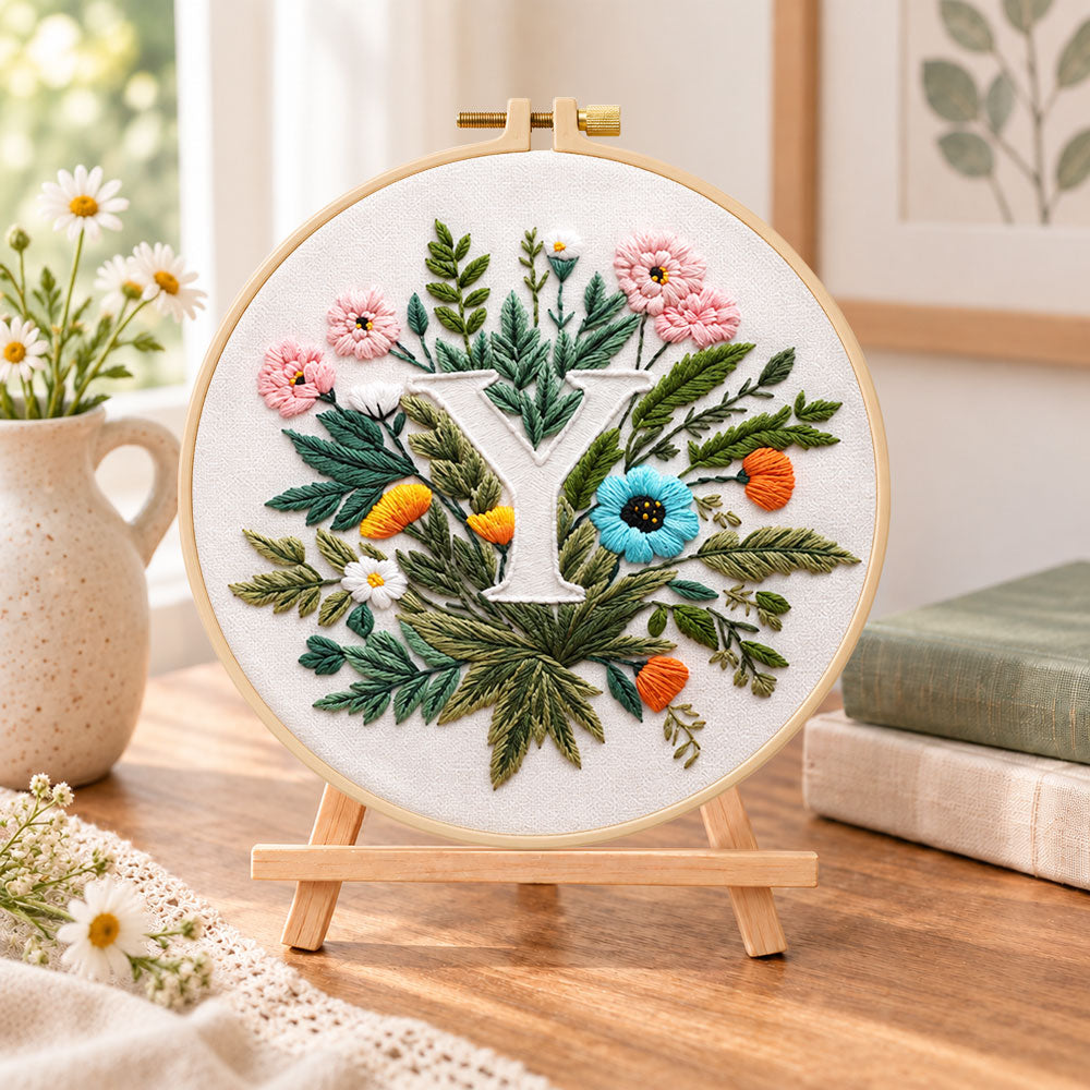 Lush greenery and letter y embroidery kit finished hoop displayed on a wooden stand as cozy tabletop decor