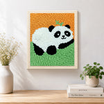 Finished lying panda with bamboo artwork displayed on a wall