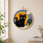 Magical black cat under the moon needle felt wall art displayed in a bright home interior