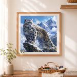 Finished majestic snow leopard on mountain peak cross stitch artwork displayed as home decor