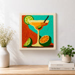 Finished margarita cocktail with lime and citrus artwork displayed on a wall