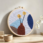 Minimalist flower arrangement punch needle artwork displayed on a table
