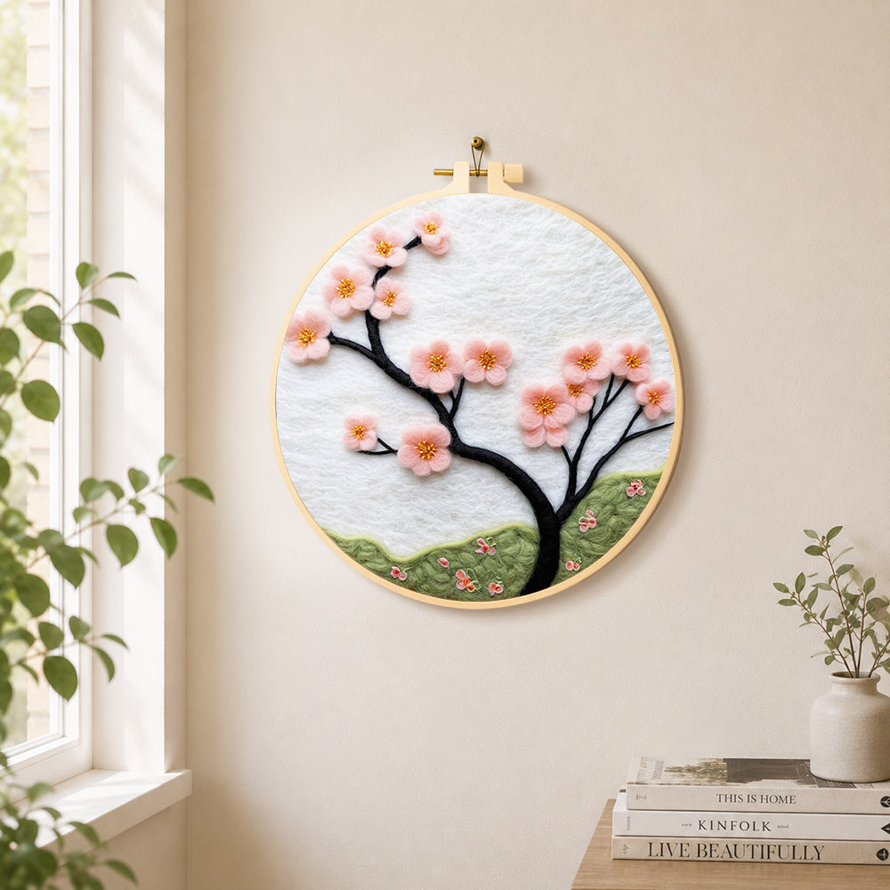Minimalist pink flower branch needle felt wall art displayed in a bright home interior