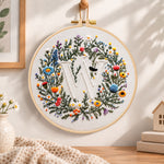 Mixed floral wreath and letter w embroidery hoop wall art displayed as warm and cozy handmade home decor