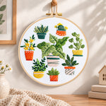 Mixed mini potted greenery embroidery hoop wall art displayed as warm and cozy handmade home decor