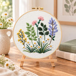 Mixed spring blooms embroidery kit finished hoop displayed on a wooden stand as cozy tabletop decor