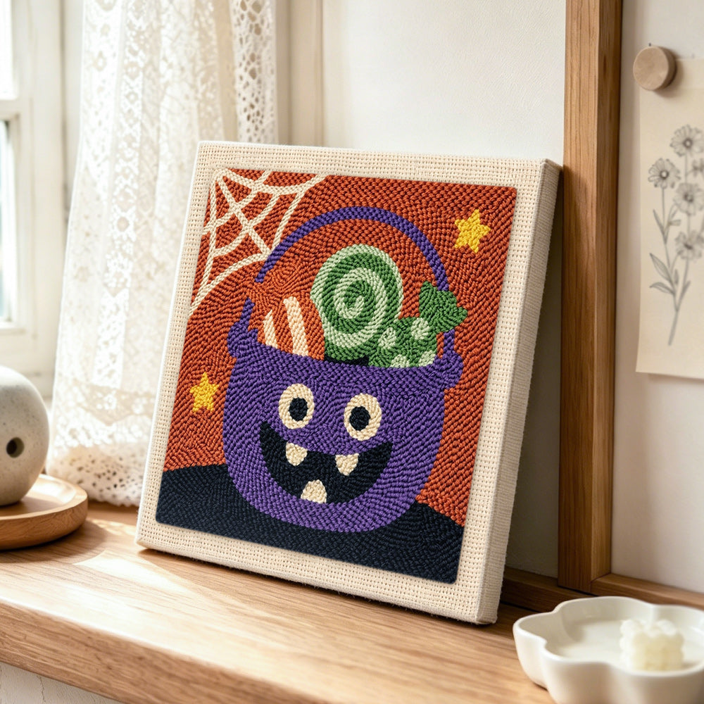 Monster candy bucket punch needle artwork displayed on a table