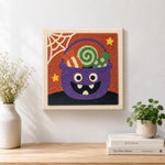Finished monster candy bucket artwork displayed on a wall
