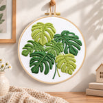 Monstera leaf embroidery hoop wall art displayed as warm and cozy handmade home decor