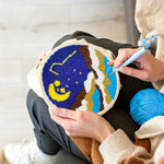 Creating handmade moon and starry night over mountains punch needle artwork