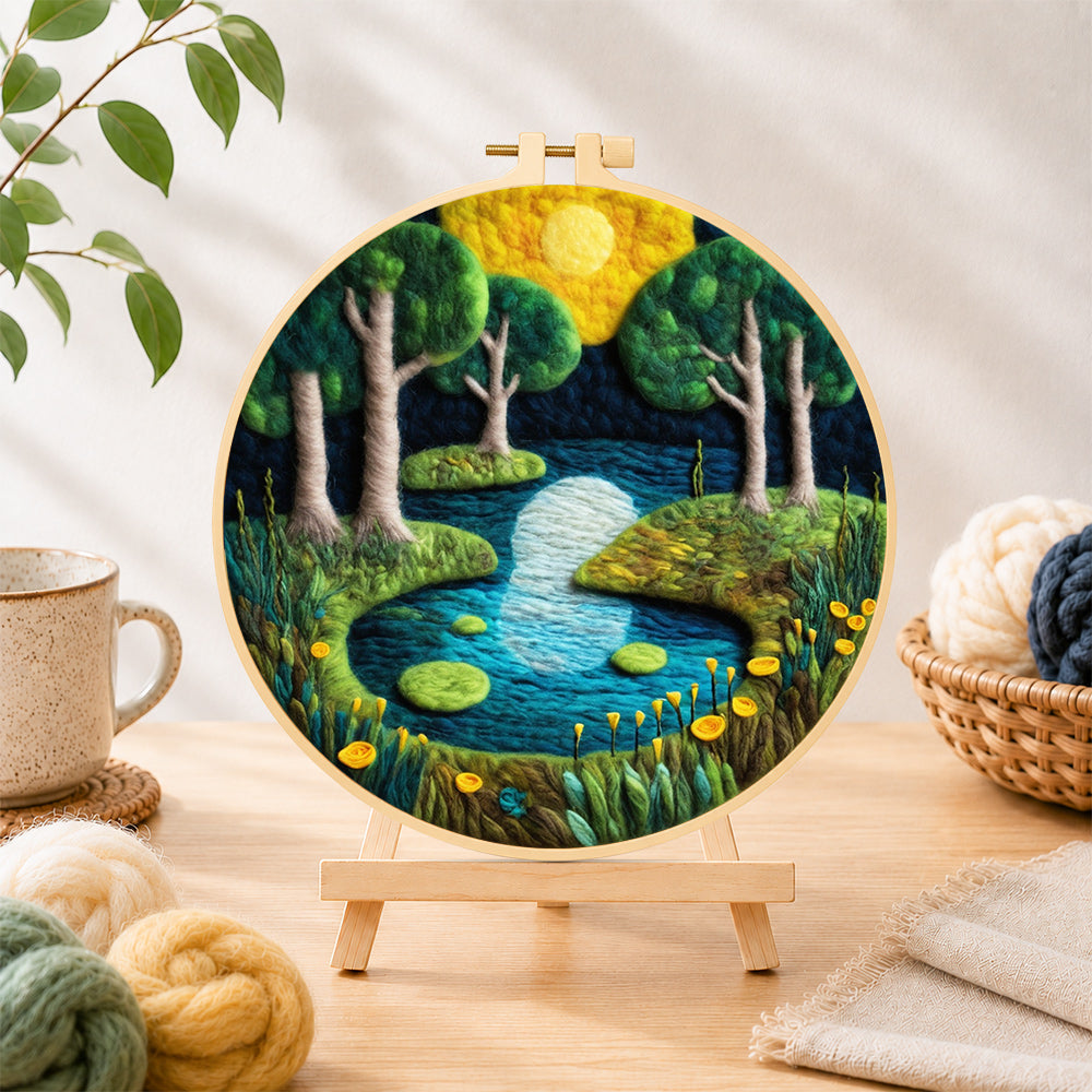 Finished moonlit forest lake moonlit forest lake needle felting displayed on a wooden easel