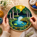Creating the moonlit forest lake wool painting by hand with a felting needle