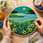 Creating the moonlit river scene with bright flowers wool painting by hand with a felting needle