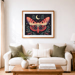 Finished moth beneath crescent moon cross stitch artwork displayed as home decor