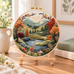 Mountain lake autumn landscape embroidery kit finished hoop displayed on a wooden stand as cozy tabletop decor