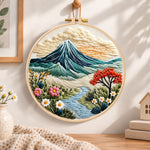 Mountain riverside landscape embroidery hoop wall art displayed as warm and cozy handmade home decor