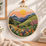 Mountain sunset meadow embroidery hoop wall art displayed as warm and cozy handmade home decor