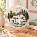 Mountain winter camp embroidery kit finished hoop displayed on a wooden stand as cozy tabletop decor