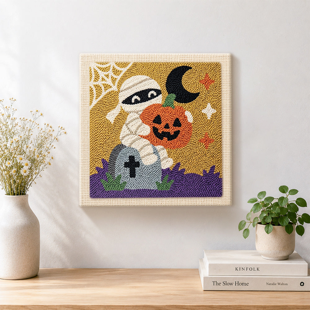 Finished mummy holding pumpkin artwork displayed on a wall