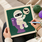 Creating handmade mummy on the toilet punch needle artwork