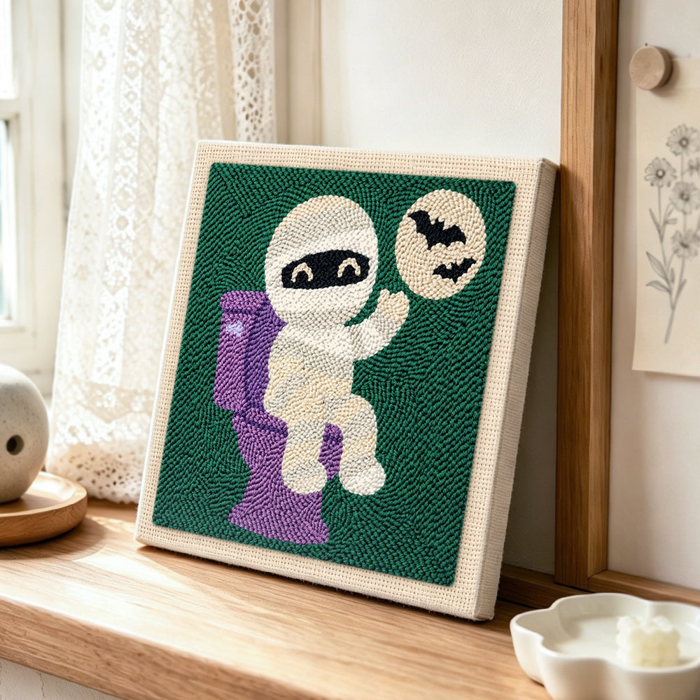 Mummy on the toilet punch needle artwork displayed on a table