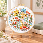 Mushroom and butterfly garden embroidery kit finished hoop displayed on a wooden stand as cozy tabletop decor