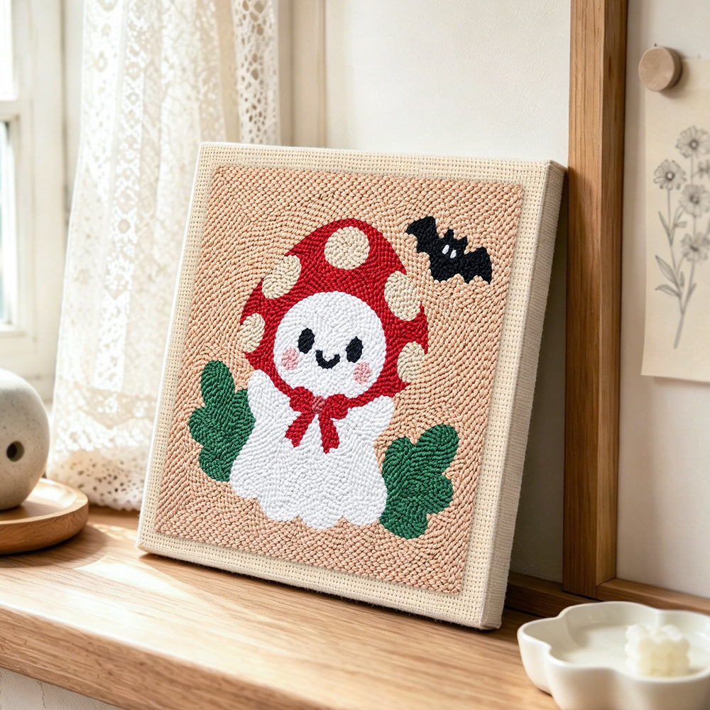 Mushroom hat little ghost punch needle artwork displayed on a table