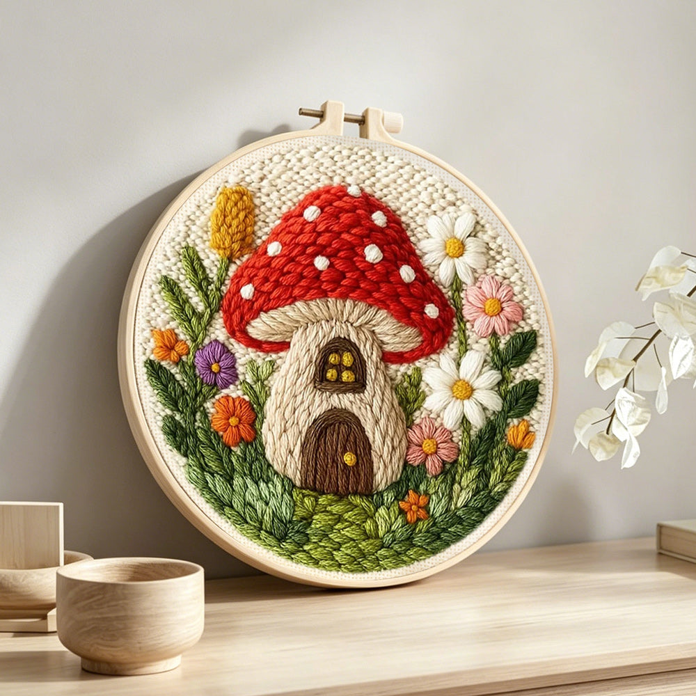 Mushroom house punch needle artwork displayed on a table
