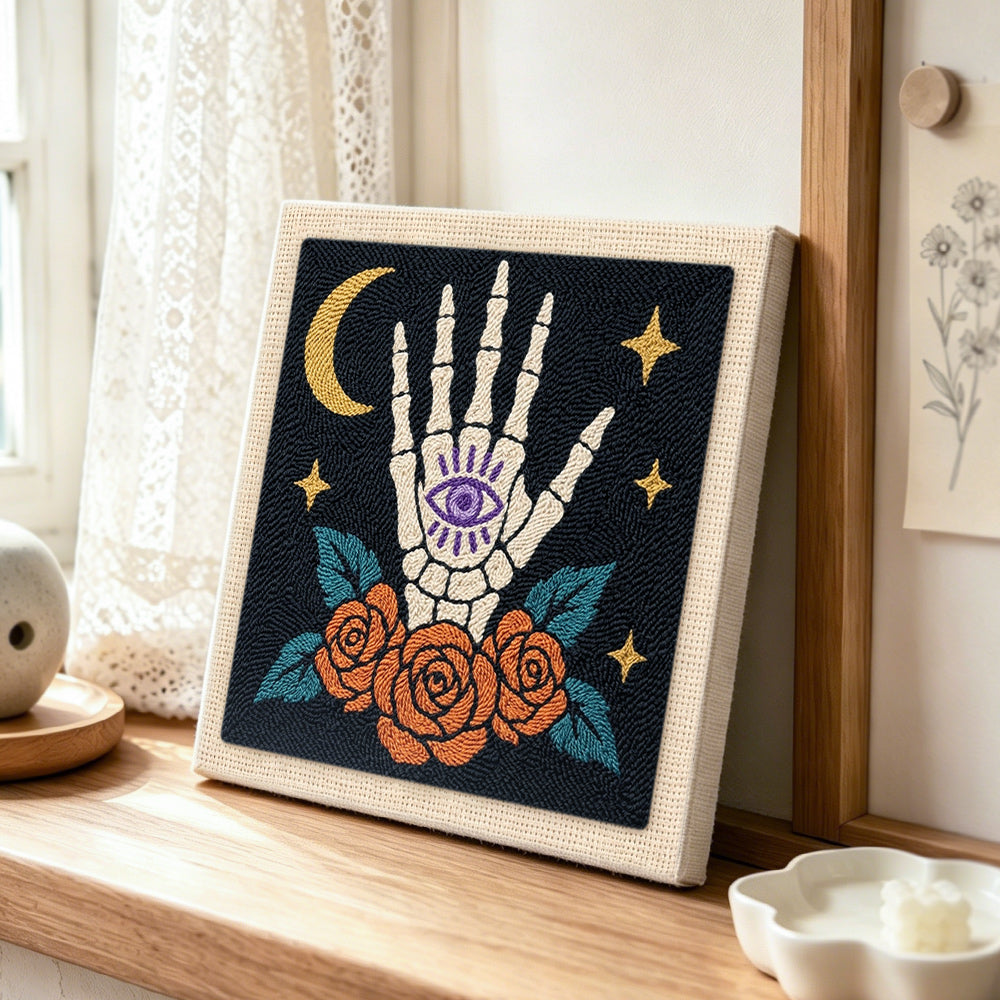 Mystic skeleton hand punch needle artwork displayed on a table