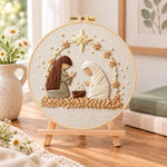 Nativity scene embroidery kit finished hoop displayed on a wooden stand as cozy tabletop decor