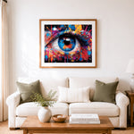 Finished neon paint splash eyeball cross stitch artwork displayed as home decor