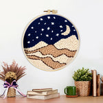 Finished night sky with moon, stars and beige sand dunes artwork displayed on a wall