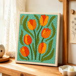 Orange and yellow tulip flowers punch needle artwork displayed on a table