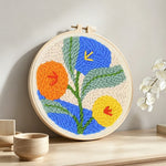 Orange, blue and yellow blooms punch needle artwork displayed on a table